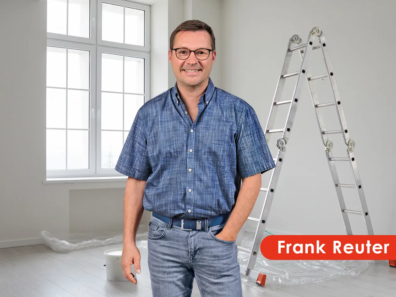 Frank Reuter in einem hellen Raum mit Leiter und Abdeckfolie