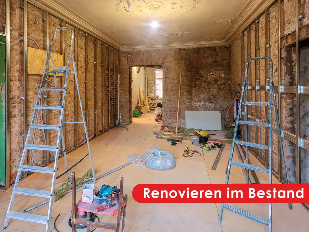 Renovieren im Bestand: entkernter Altbauraum mit Leitern und Baumaterial