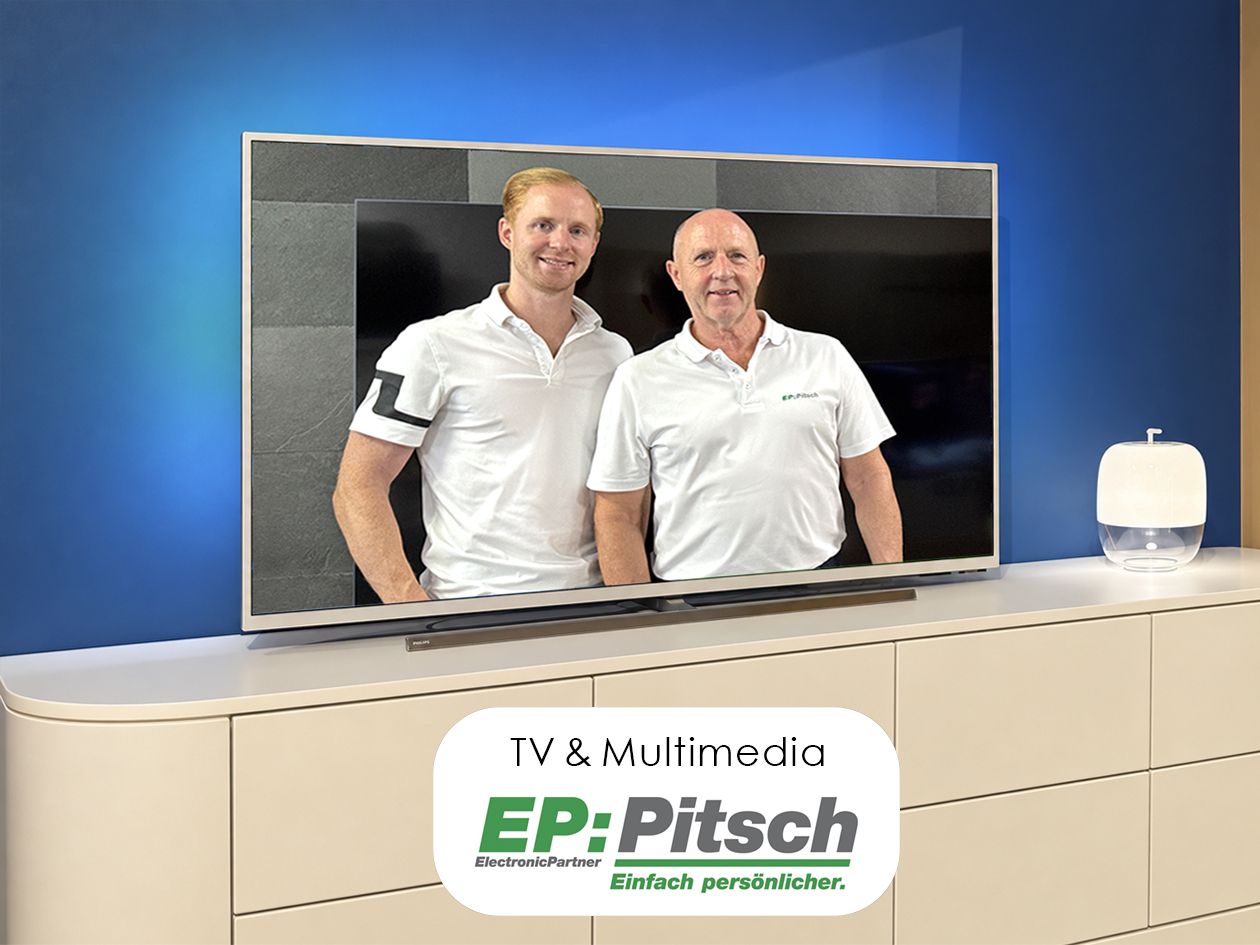 Fernseher auf einem Sideboard im Musterzimmer, auf dem Bildschirm die beiden Inhaber von EP:Pitsch